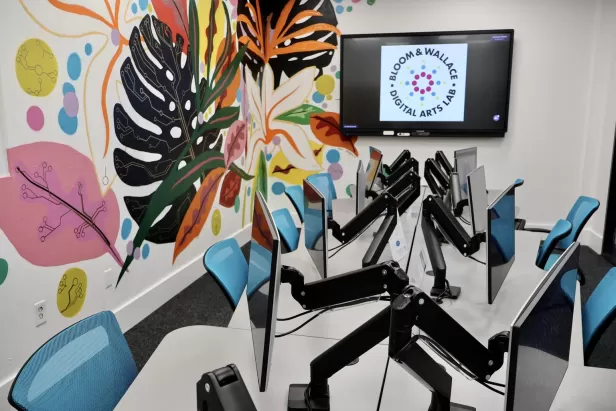 image of a computer lab with teal office chairs and colorful plants painted on the wall
