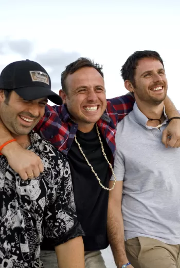 A group of men standing next to each other near the ocean
